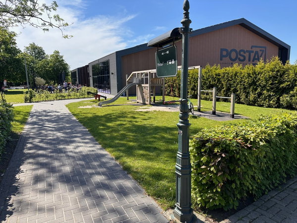 Wandelpad naar de ingang van Posta7 in Tolbert met lantaarn en hagen