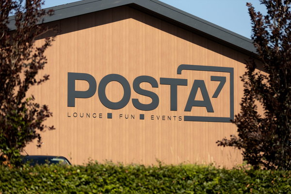 Het Posta7-logo met Lounge Fun Events op de houten gevel van de hal