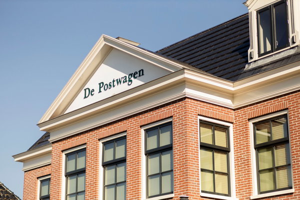 De naam De Postwagen op het fronton van het monumentale pand in Tolbert