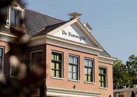 Zijaanzicht van De Postwagen met de gevelsteen en de grote ramen