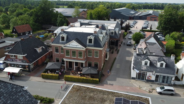 Luchtfoto van De Postwagen met de zalen en het terras aan de Hoofdstraat in Tolbert