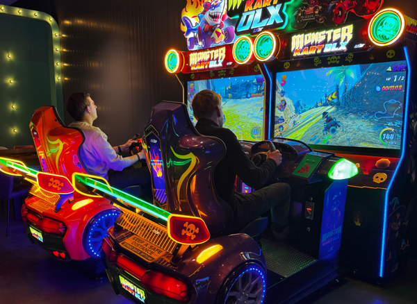 Twee spelers racen in de arcade-racesimulators van de PostArcade gamehal bij Posta7