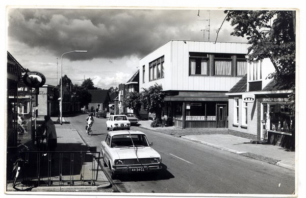 Straatbeeld van de Hoofdstraat in Tolbert in de jaren zeventig met De Postwagen