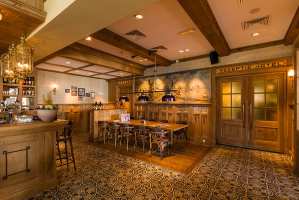 Eethoek met lange tafel en wandschildering in restaurant De Postwagen