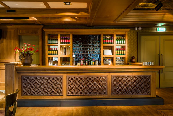 De houten bar met wijnrek in zaal Dorpszicht van De Postwagen