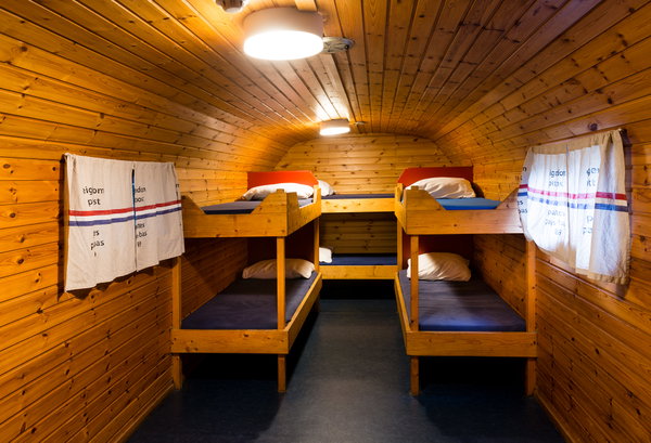 Slaapwagen met stapelbedden en gordijnen in de groepsaccommodatie