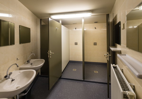 Wastafels en douchecabines in het sanitairgebouw van de groepsaccommodatie