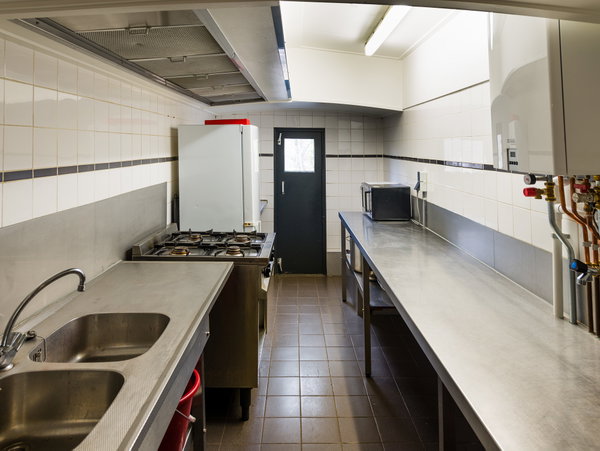 Keuken van de groepsaccommodatie met rvs-aanrecht en fornuis