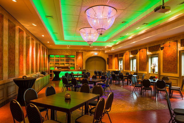 Feestzaal De Doorrit met groene verlichting en kroonluchters