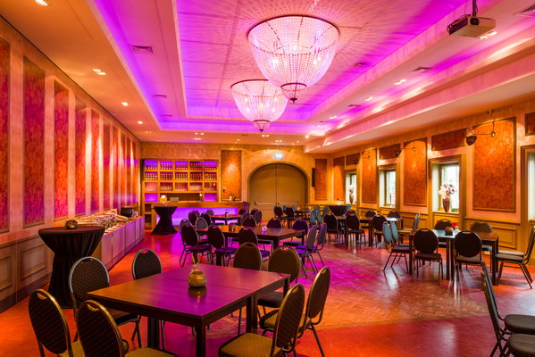 Feestzaal De Doorrit in paars licht met zicht op de bar