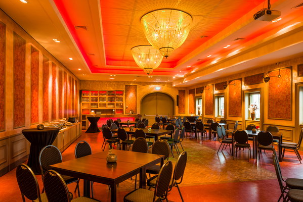 Feestzaal De Doorrit met rode sfeerverlichting en zicht op de bar