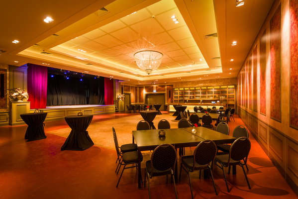 Zaal 't Koetshuis met podium en warme verlichting bij De Postwagen