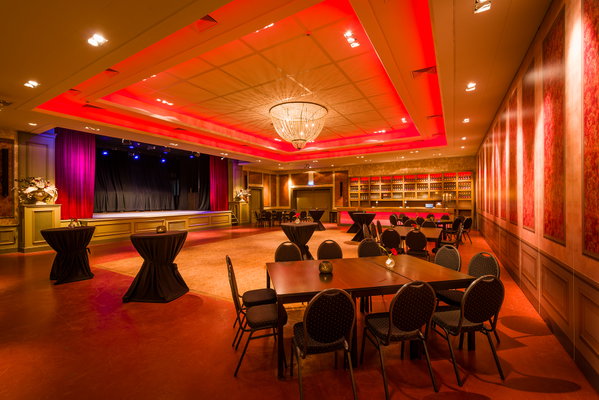 Zaal 't Koetshuis met rode verlichting klaar voor een feest of presentatie