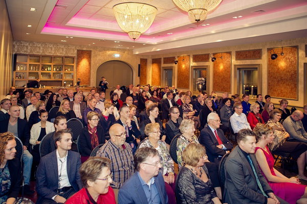 Zaal vol gasten onder de kroonluchter tijdens een bruiloft bij De Postwagen