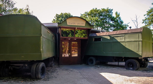 Pipowagens en de houten poort van de groepsaccommodatie bij De Postwagen