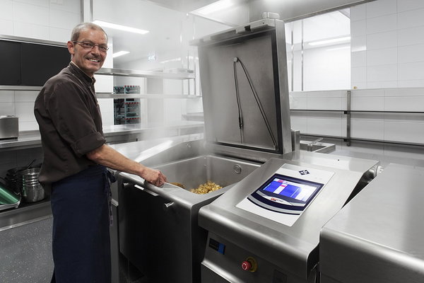 Kok aan het werk bij de kantelbraadpan in de keuken van De Postwagen