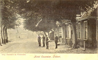 Sepia-ansichtkaart van de Hoofdstraat in Tolbert bij De Postwagen