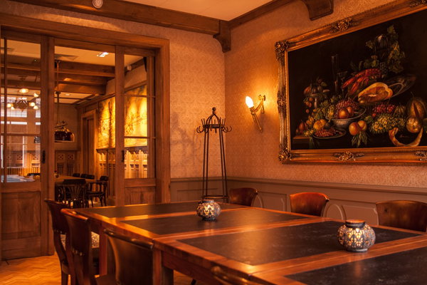 Eetzaal van restaurant De Postwagen met stilleven aan de wand en wandlampen