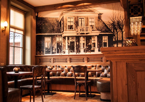 Zithoek met lederen banken en historische dorpsfoto in restaurant De Postwagen