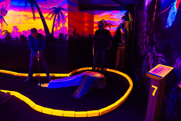 Twee spelers op hole 7 van de glow in the dark midgetgolf bij Posta7