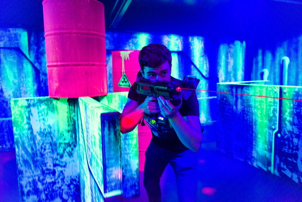 Speler richt met zijn laserfaser in de lasergame-arena van Posta7