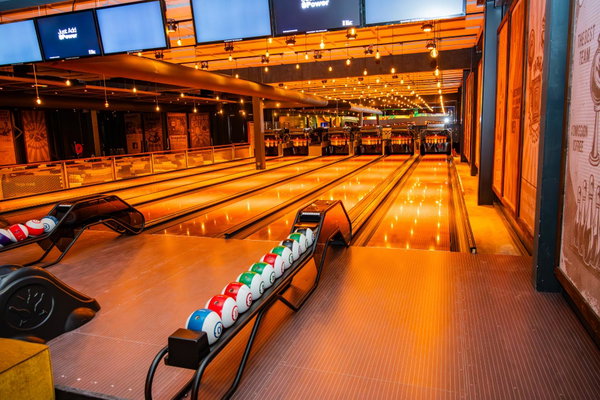 Bowlingballen in de ballenretour op de verlichte bowlingbaan van Posta7