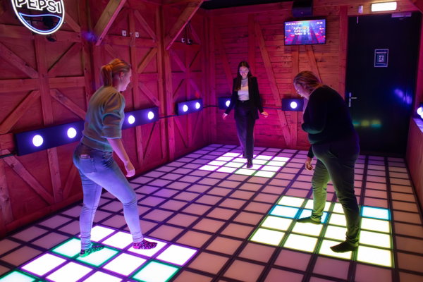Spelers springen over de verlichte tegels van de FlashFloor bij Posta7