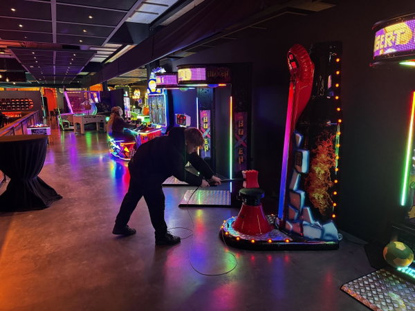 Speler aan een arcadekast in de PostArcade gamehal van Posta7
