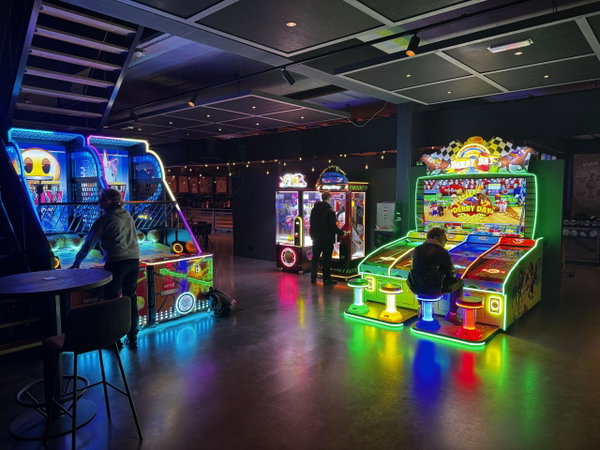 De PostArcade gamehal van Posta7 met verlichte arcadekasten
